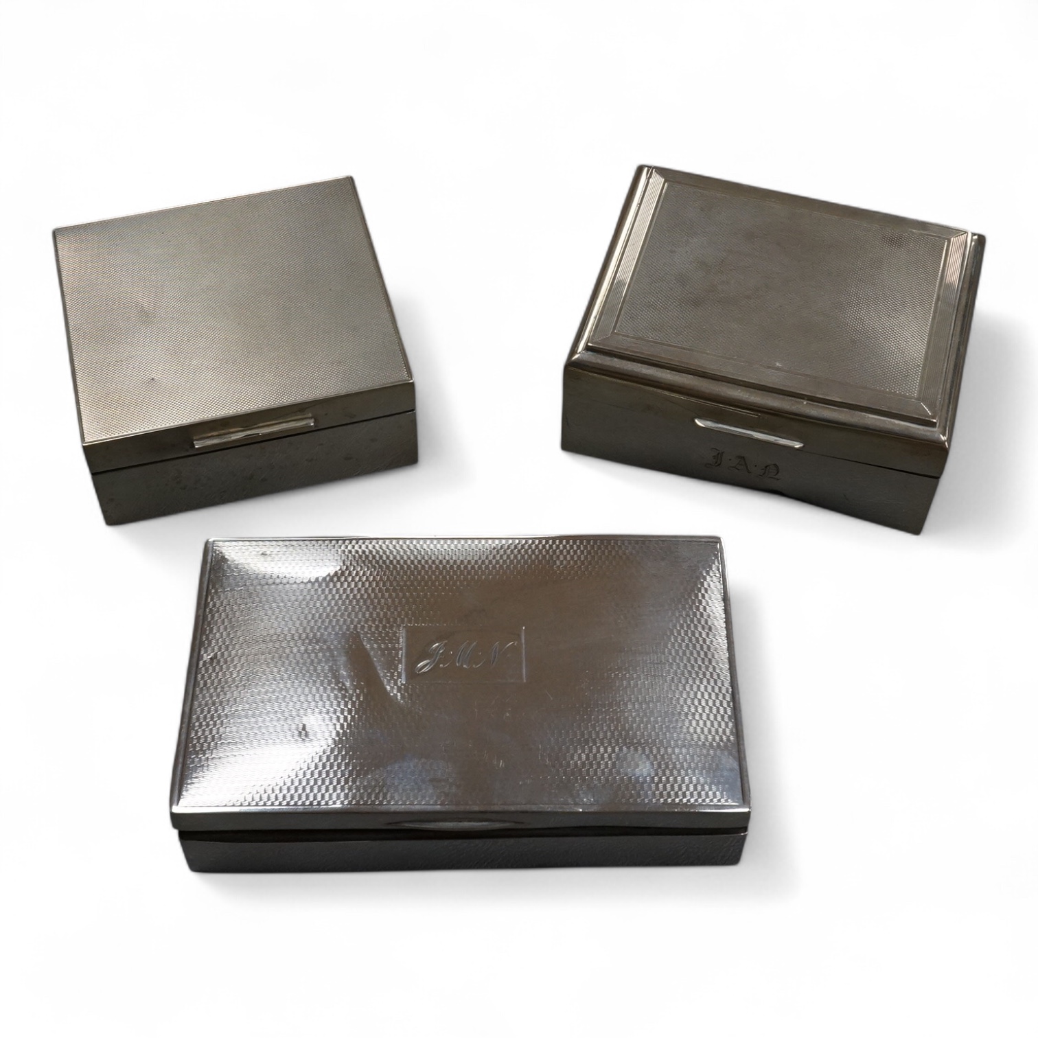 Three assorted silver mounted cigarette boxes, the largest by Frederick William Hentsch, London, 1924, 14.3cm.